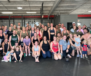 A group of CrossFit athletes celebrate after finishing a workout.